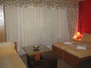 a room with two beds and a table and a window at Villa Ohrid Anastasia in Ohrid