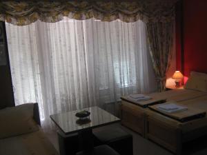 a room with a bed and a table and curtains at Villa Ohrid Anastasia in Ohrid