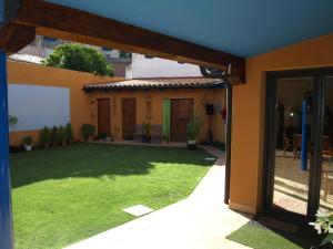 un patio con prato di fronte a una casa di Hotel Rural Las Águedas a Ventosa