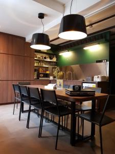 a dining room with a wooden table and black chairs at Wink at Mosque Street in Singapore