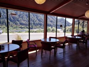 a restaurant with tables and chairs and a large window at Berlins cafe, bar and backpackers in Newton Flat