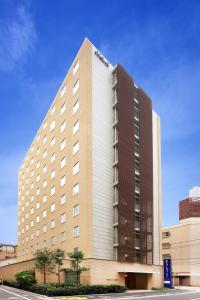 ein großes Hotelgebäude mit blauem Himmel im Hintergrund in der Unterkunft Keio Presso Inn Gotanda in Tokio