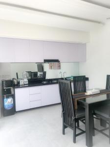 a kitchen with white cabinets and a table and chairs at Bali Villas Arta in Seminyak
