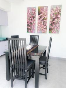a dining room table with two chairs and two paintings at Bali Villas Arta in Seminyak