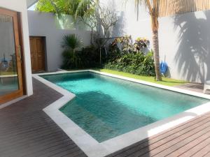a swimming pool in the middle of a house at Bali Villas Arta in Seminyak
