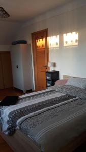 1 dormitorio con 1 cama grande y puerta en Chambre Coquette, en Aulnay-sous-Bois