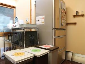 a kitchen with a refrigerator and a counter top at Guest House Minato in Miyako