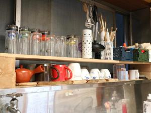 a shelf filled with glass jars and utensils at Guest House Minato in Miyako