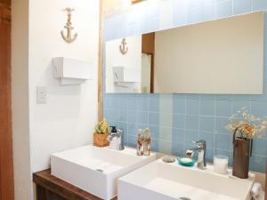 a bathroom with two sinks and a mirror at Guest House Minato in Miyako