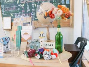 a table with a bottle and a vase with flowers at Guest House Minato in Miyako