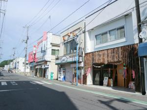 an empty city street with shops and buildings at Guest House Minato in Miyako
