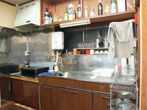 a kitchen with a sink and a counter top at Guest House Minato in Miyako