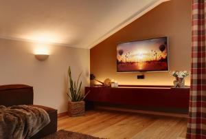 sala de estar con TV de pantalla plana en la pared en Crioli Dolomiti Lodge en Villabassa