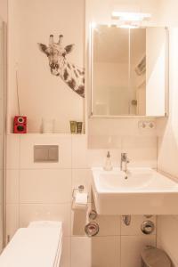 a bathroom with a giraffe sticking its head in the mirror at Ringpark-Ferien in Würzburg
