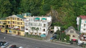 un gran edificio blanco con sombrillas verdes en una calle en Guest House Palma en Sarpi