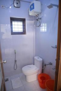 a white bathroom with a toilet and a shower at PAVITHRAM RESIDENCY in Kollam