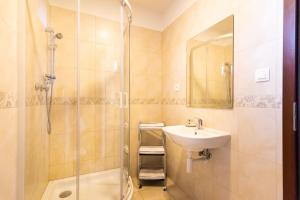 W łazience znajduje się umywalka i prysznic. w obiekcie Villa Ephélia w mieście Dunajská Streda