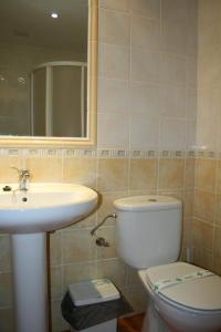 a bathroom with a toilet and a sink at Apartamentos Mirasierra in Coto Ríos