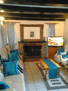 a living room with a couch and a fireplace at Ondini Guest House in Winterton