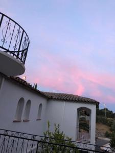 a white building with a balcony and a sunset at Maxima Sunset in Sainte-Maxime