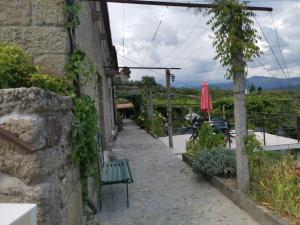 a stone alley with a bench and an umbrella at Casa da Eira - Castanheiras in Resende