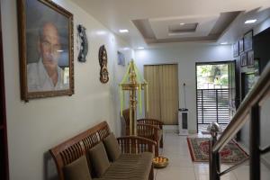 a living room with a picture of a man on the wall at PAVITHRAM RESIDENCY in Kollam