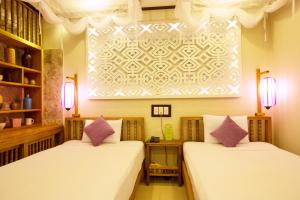 Postel nebo postele na pokoji v ubytování Hoi An Pho Library Hotel