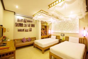 Postel nebo postele na pokoji v ubytování Hoi An Pho Library Hotel