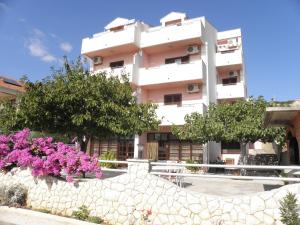 un edificio con flores rosas delante de él en Apartments Katarina en Sveti Petar