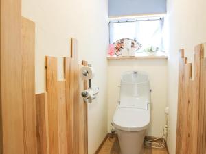 a bathroom with a toilet and a window at Guest House Minato in Miyako