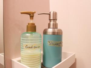 two bottles of soap sitting in a holder at Guest House Minato in Miyako
