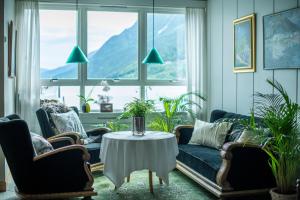 a living room with couches and a table in front of a window at Skjolden Hotel in Skjolden