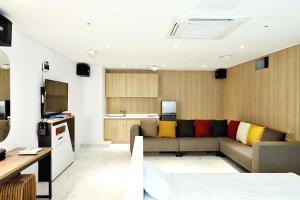 Biennale Hotel في غوانغجو: غرفة معيشة مع أريكة ومطبخ