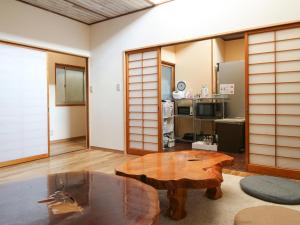 a room with a table and a room with a kitchen at Guest House Minato in Miyako