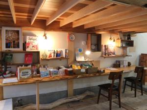 a room with a long counter with a table and chairs at Guest House Minato in Miyako