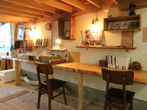 a kitchen with a wooden bar with two chairs at Guest House Minato in Miyako