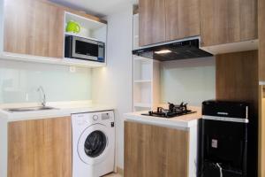 Η κουζίνα ή μικρή κουζίνα στο 2BR with Sofa Bed at Springlake Summarecon Apartment By Travelio