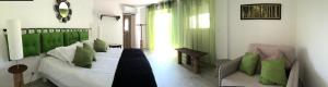 a living room with a bed with green pillows at Maxima Sunset in Sainte-Maxime