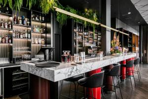 - un bar avec un comptoir en marbre et des tabourets dans l'établissement Clarion Hotel Oslo, à Oslo