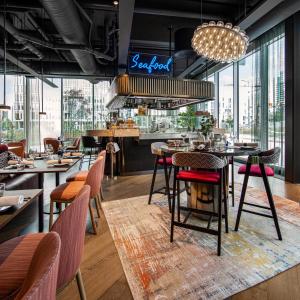 a restaurant with tables and chairs and a bar at Clarion Hotel Oslo in Oslo