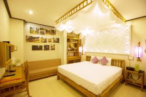 Postel nebo postele na pokoji v ubytování Hoi An Pho Library Hotel