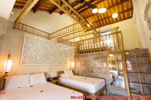 Postel nebo postele na pokoji v ubytování Hoi An Pho Library Hotel