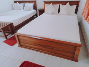 a couple of beds in a room at Lake Side Tourist Inn in Tissamaharama
