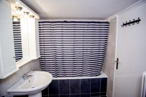 a bathroom with a sink and a shower curtain at Thessaloniki Center Apartment On The Sea in Thessaloniki
