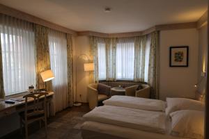 a hotel room with two beds and a desk at Hotel-Restaurant & Metzgerei Rößle in Dettingen an der Erms