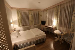 um pequeno quarto de hotel com uma cama e uma secretária em Hotel-Restaurant & Metzgerei Rößle em Dettingen an der Erms