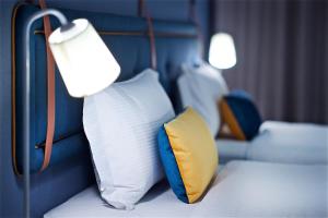 a room with two beds with pillows and a lamp at Just Sleep - Ximending in Taipei