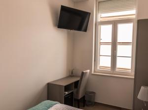 Un dormitorio con un escritorio y un televisor en la pared. en Rirooms, en Rijeka 21 fotos más