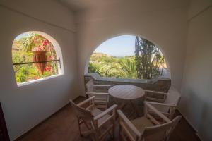 a room with a table and chairs and two windows at amorgaia3 in Katapola