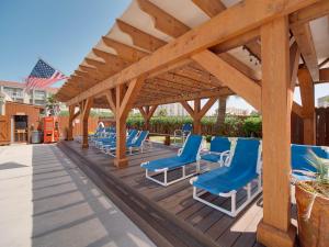 un gruppo di sedie blu su una terrazza di legno di Relaxing Condo, Great Location, 3 Minute Walk To The Beach Condo a South Padre Island